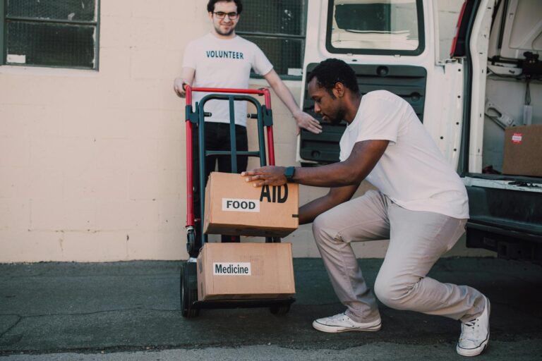 Volunteers organizing and loading boxes of aid, food, and medicine for donation.